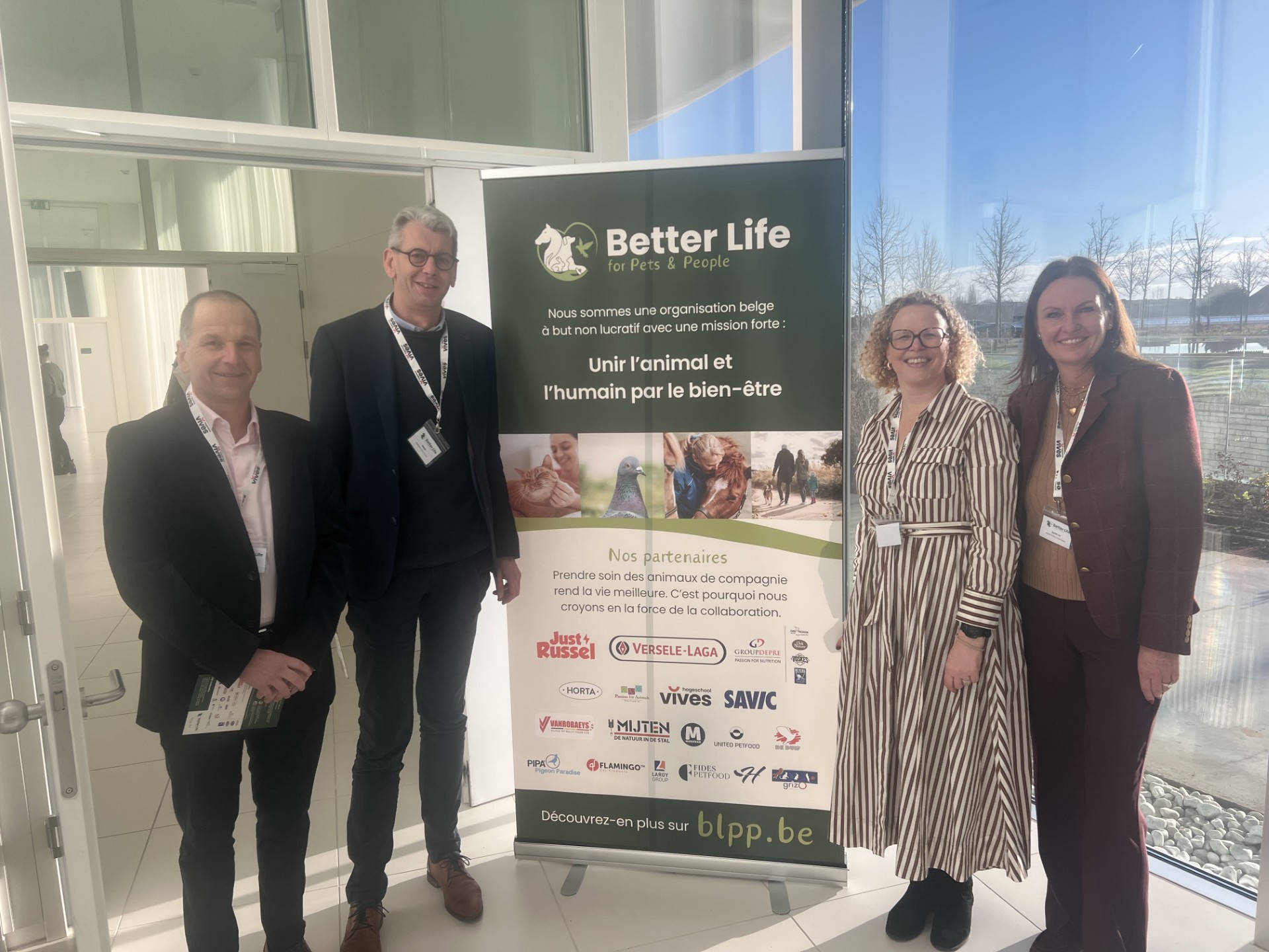 Savic representatives at the launch of Better Life for Pets & People in Belgium, standing next to the BLPP banner with partner logos