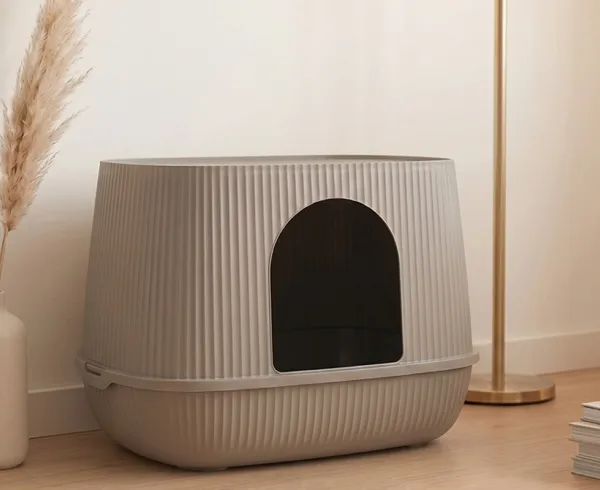 Savic Moona covered cat litter box in warm grey with ribbed structure, in a light living room.